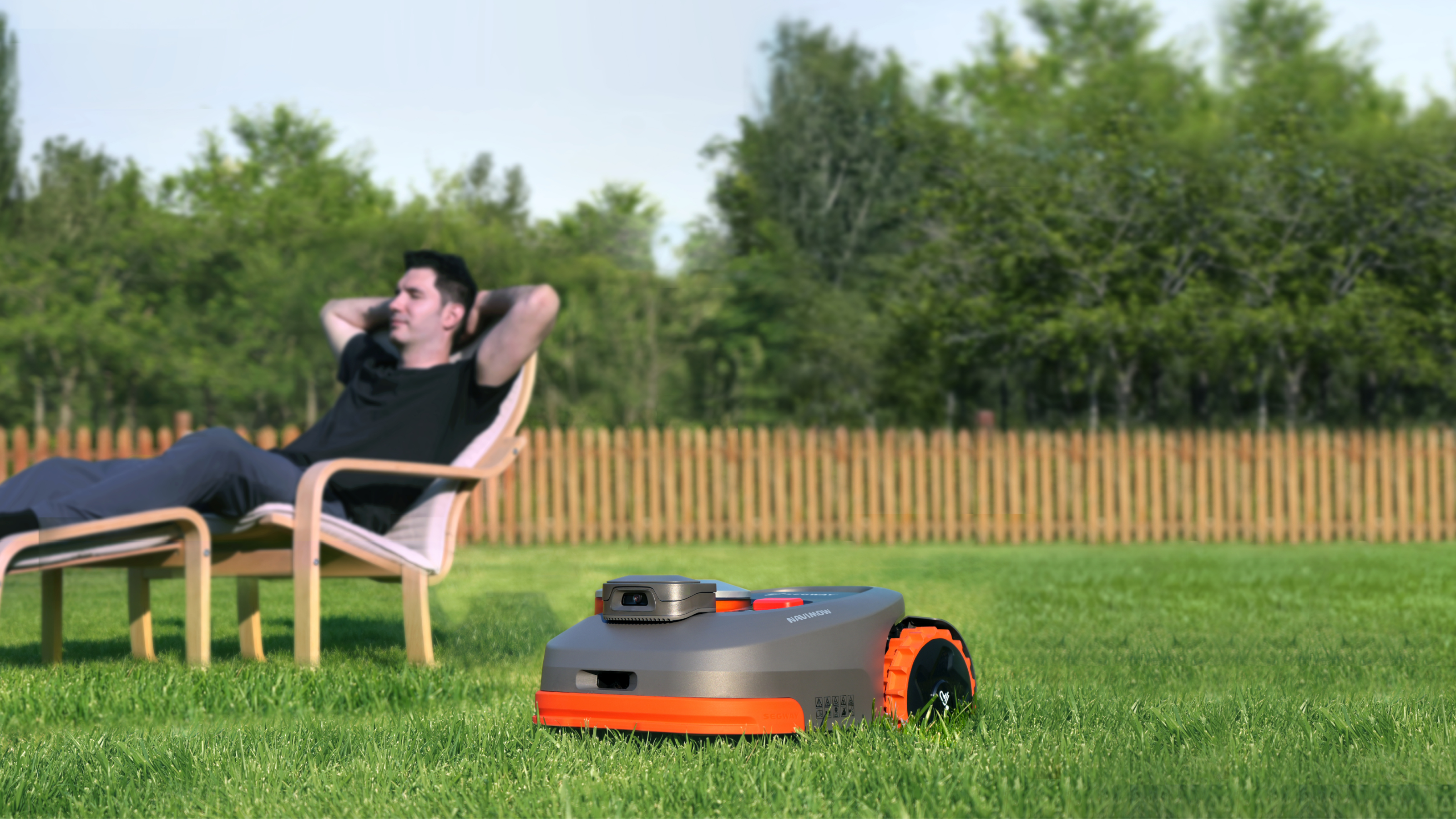 robot mowers working beside a man