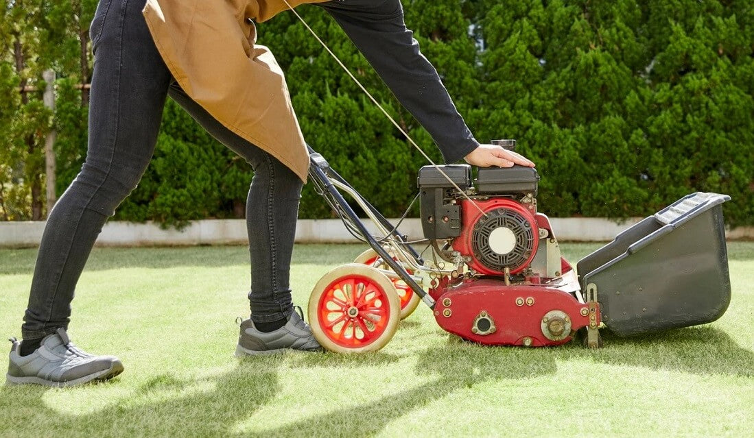 Person starting lawn mower on grass, not Segway Navimow