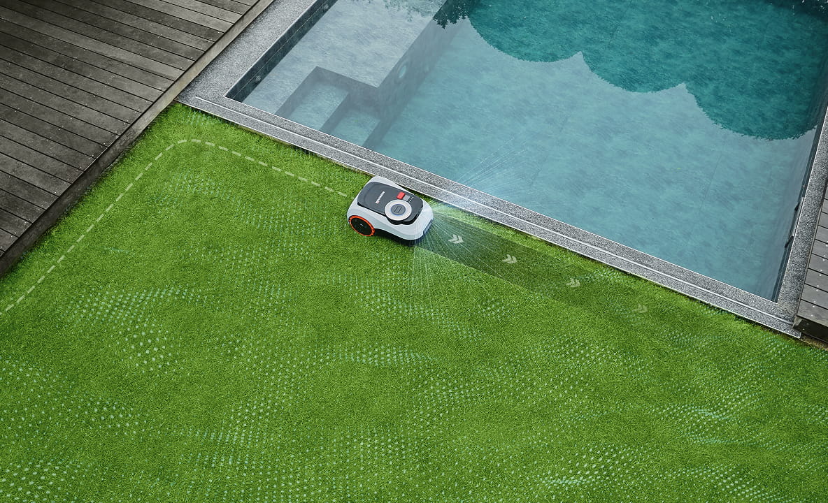 Navimow i2 LiDAR robot lawn mower trims green grass near pool.